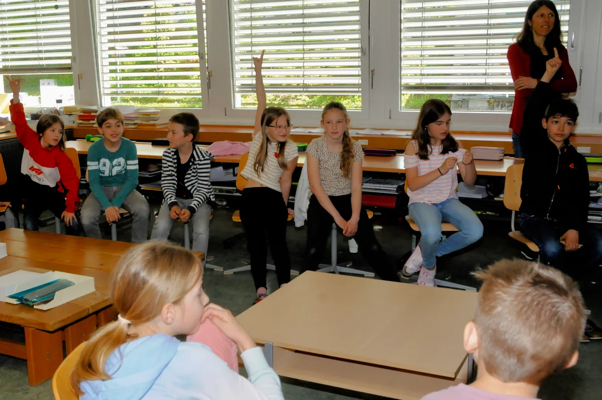 Man sieht Schulkinder ihr Schulprojekt vorstellen.